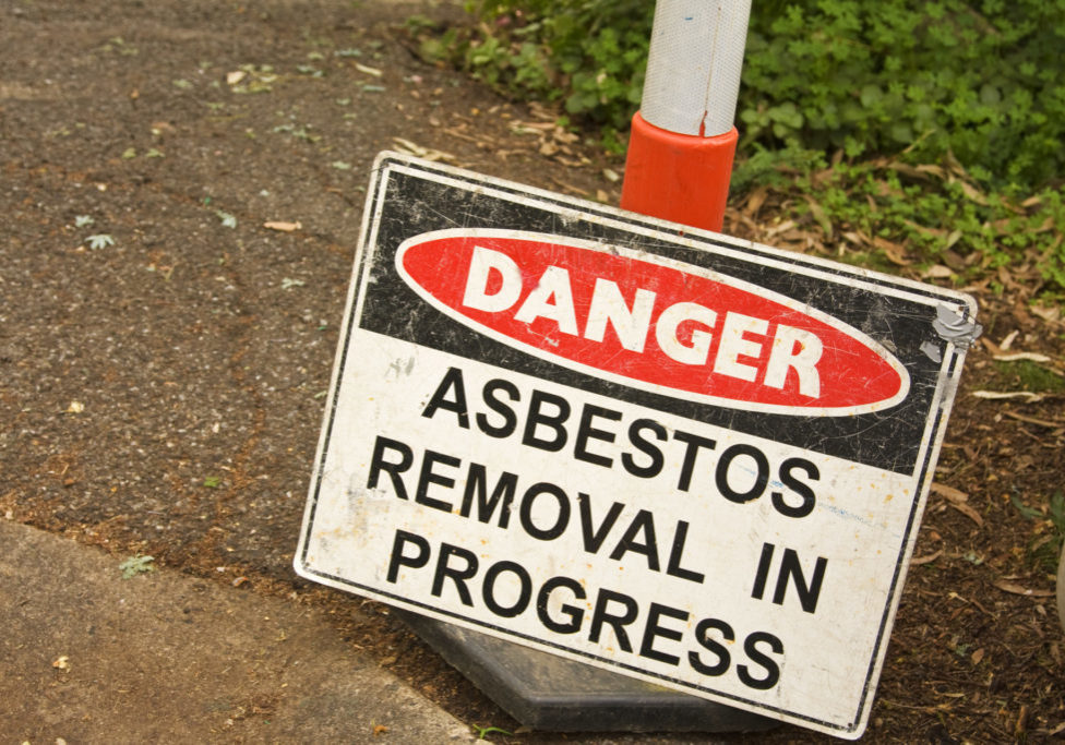 Warning sign in front of a house where an asbestos roof is being removed.